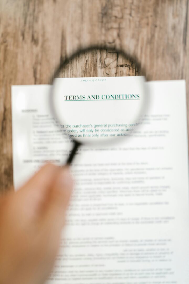 Magnifying glass focusing on 'Terms and Conditions' in a document. Ideal for business and legal themes.
